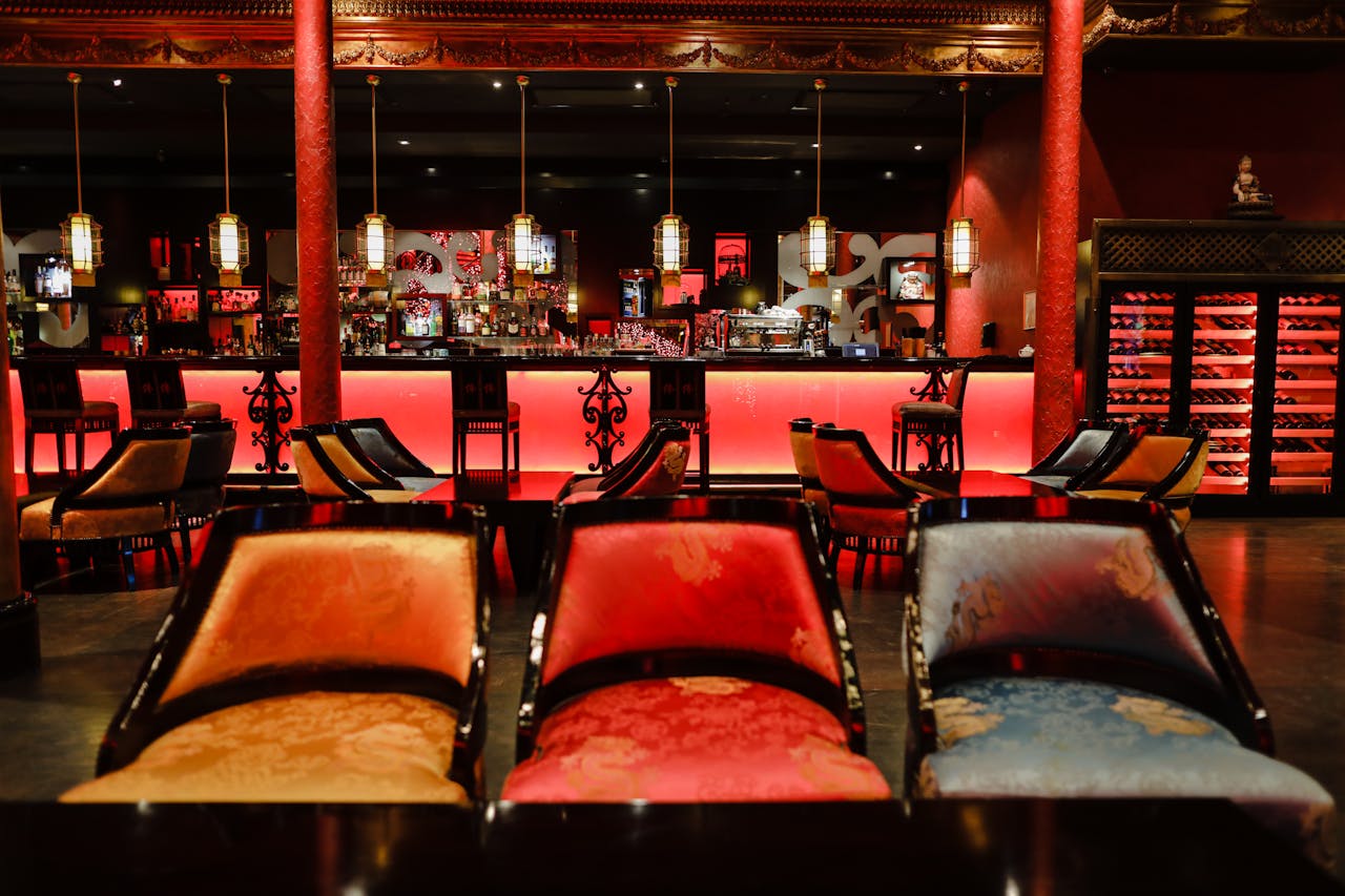 Luxurious and vibrant Asian-inspired restaurant interior with colorful chairs and ambient lighting.